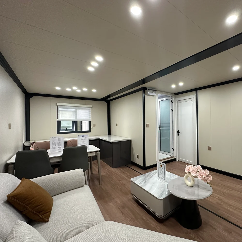 Furnished interior with a sofa, coffee table, dining table and cabinetry beneath a window.