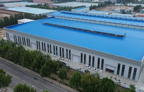 01-qinbo-factory-factory-overview Aerial view of the manufacturing partner’s factory building with blue roofs.