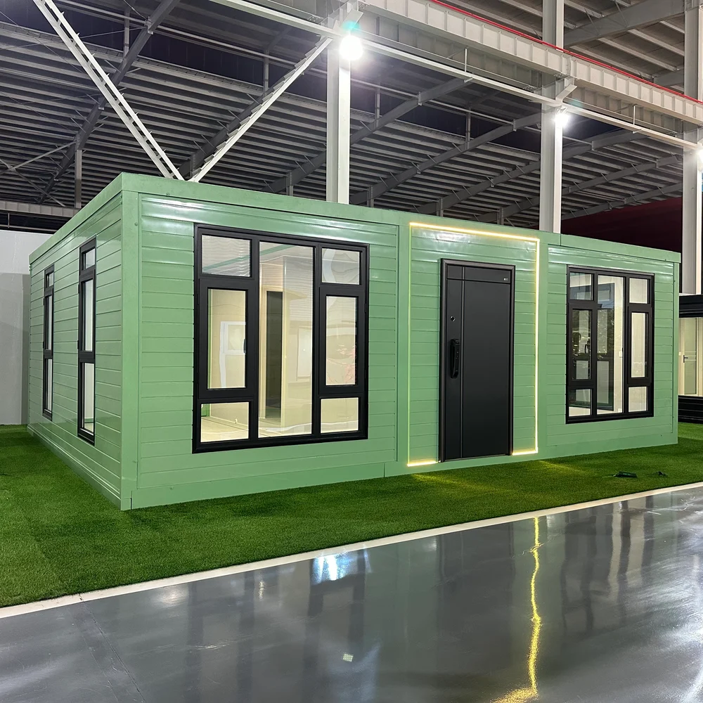 Qinbo Modern 20 — Green Exterior — Large Windows Pale green expandable home with large dark-framed windows and illuminated trim around a dark entrance door.