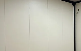 Warm beige bamboo-wood fibre wall panels showing the surface and vertical joints.