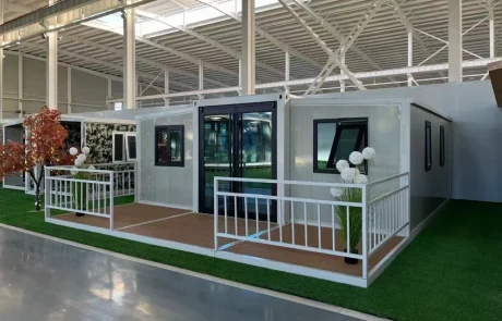 Expandable home with an uncovered deck, white railings and timber-look decking.