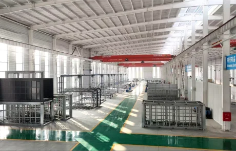 02-qinbo-factory-production-hall Expandable-house frames arranged along an aisle inside the factory production hall.