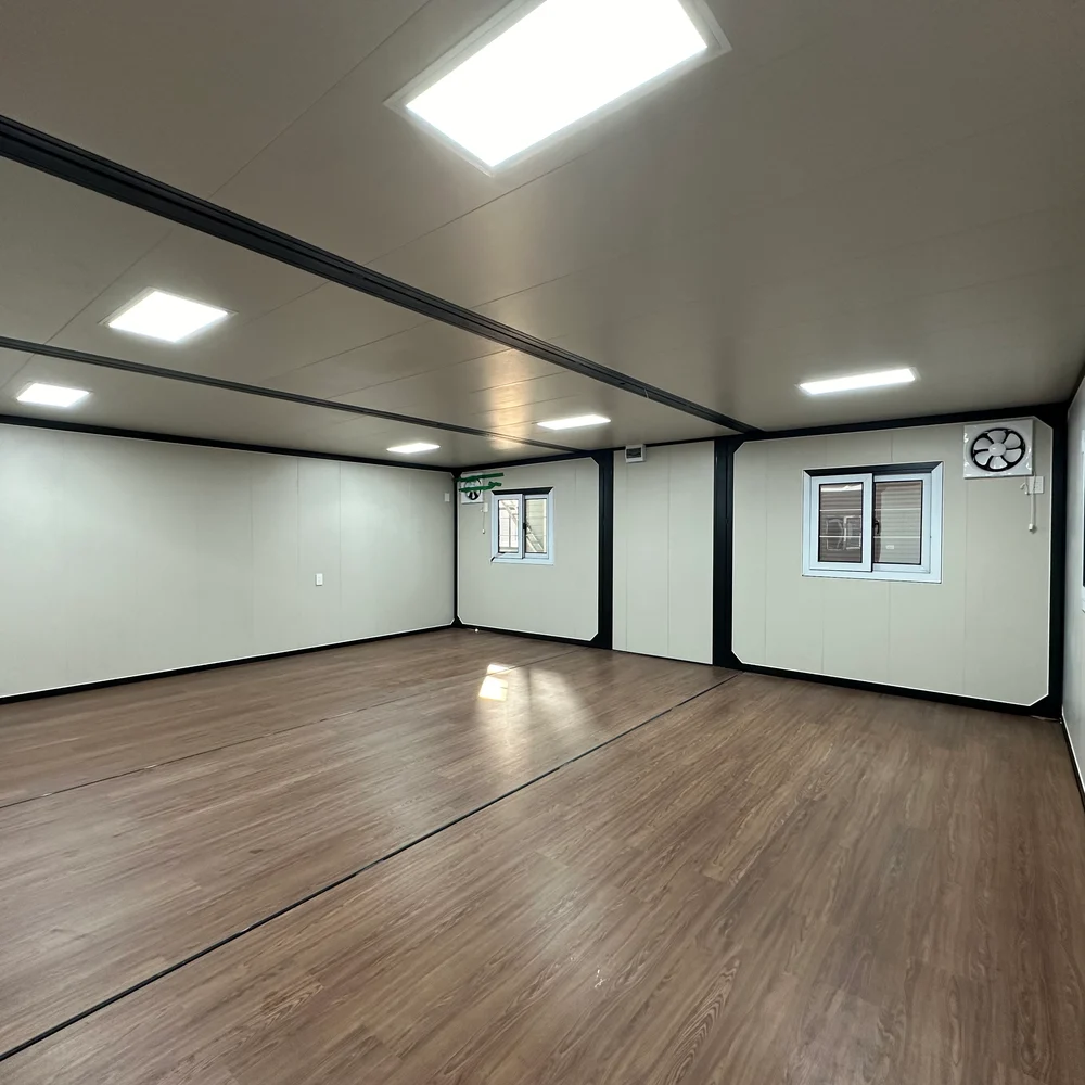 Qinbo Modern 20 — Open Interior — Windows and Ventilation Open unfurnished interior with brown wood-look flooring, two windows and a wall-mounted ventilation fan.