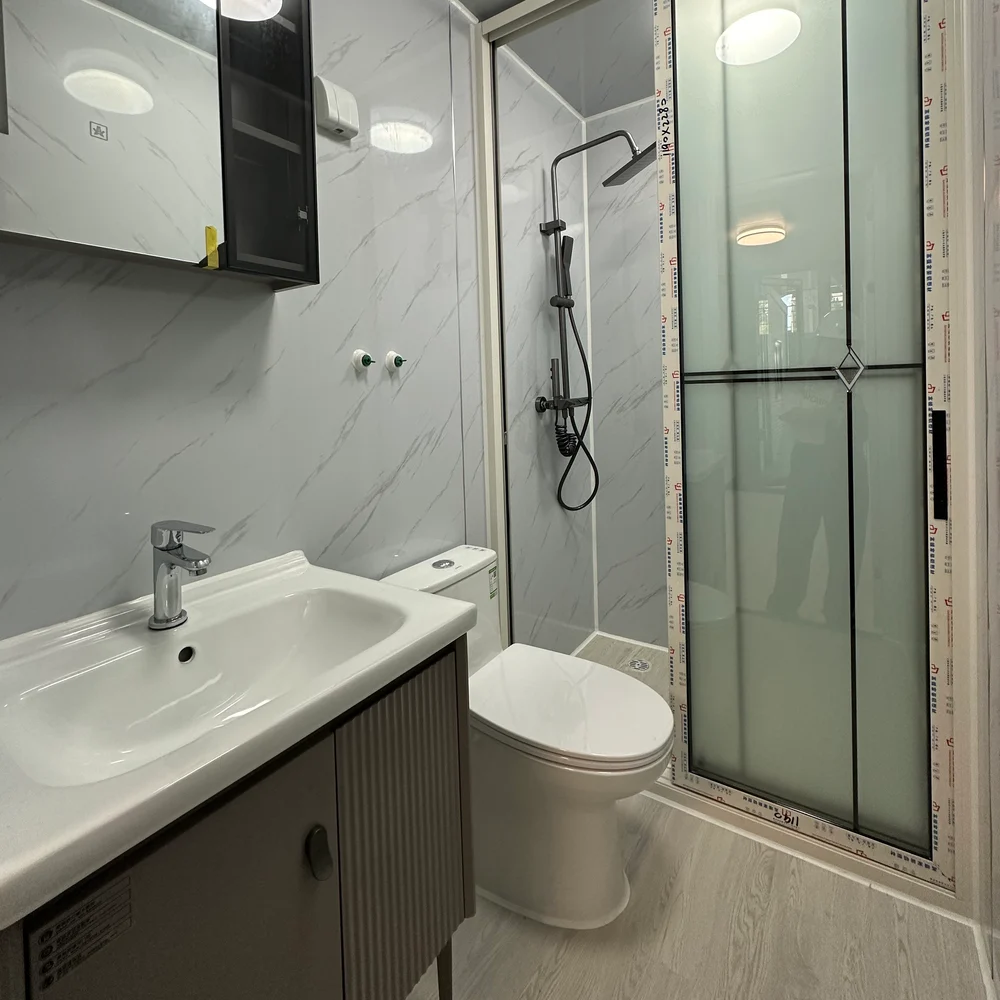 Qinbo Modern 20 — Bathroom — Ribbed-Front Vanity Bathroom with a ribbed-front vanity, toilet and glazed shower enclosure with overhead and handheld shower fittings.