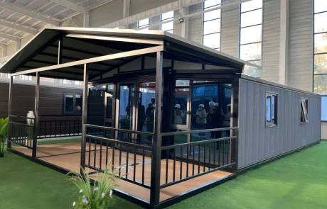 Expandable home with a black-frame veranda, matching railings and a pitched canopy over the deck.