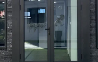 Dark-framed double hinged glazed entrance doors.