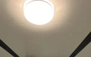 Round surface-mounted ceiling light in a finished expandable-home interior.