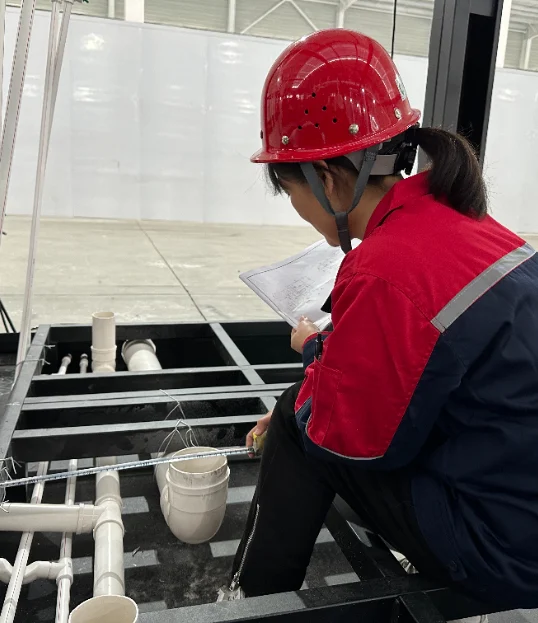 Inspector checking water and waste pipes in the floor frame.